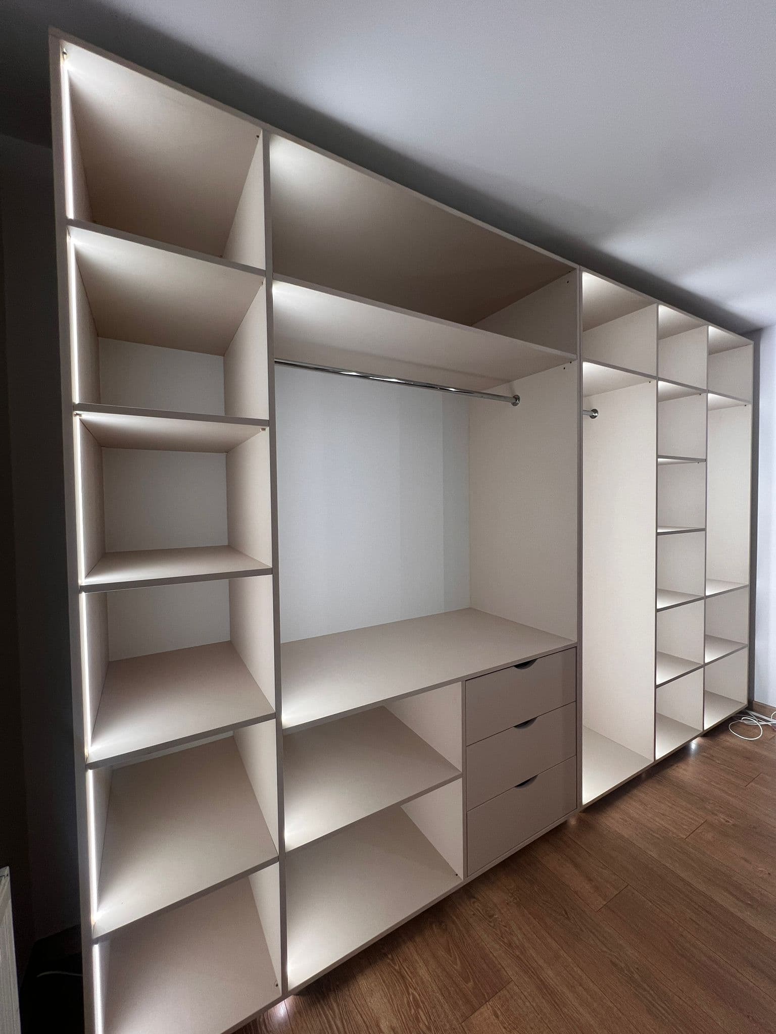 Detaliu interior al dressingului, cu sertare, polițe și iluminare.
