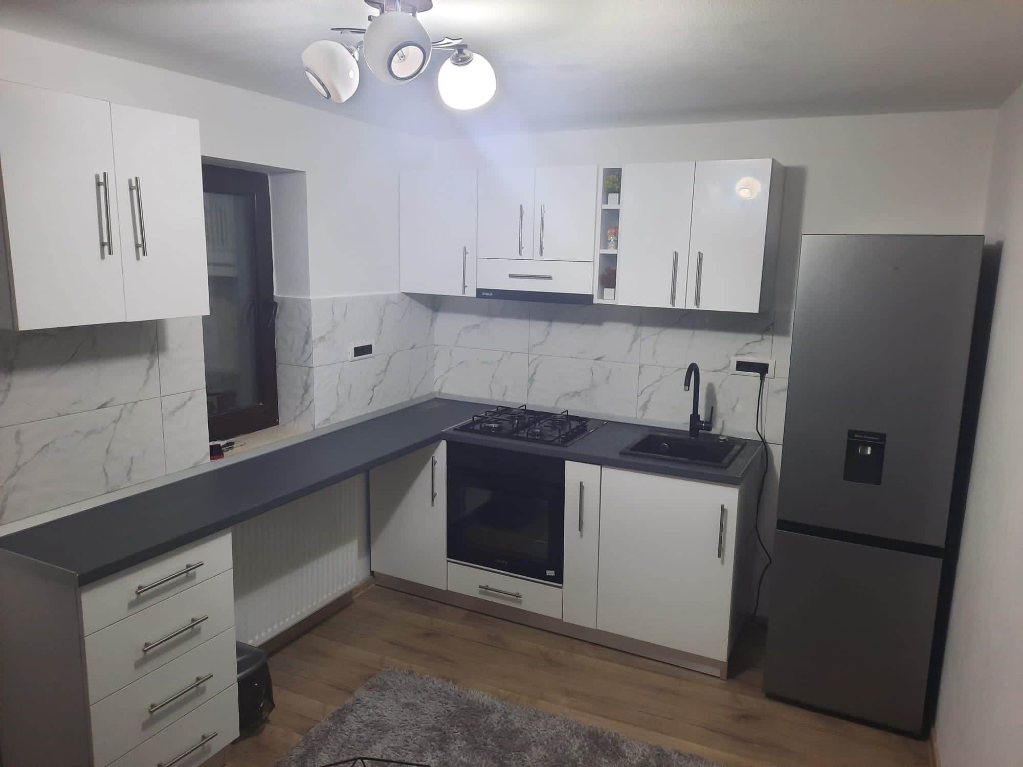 Bucătărie cu mobilier configurat pe două laturi.